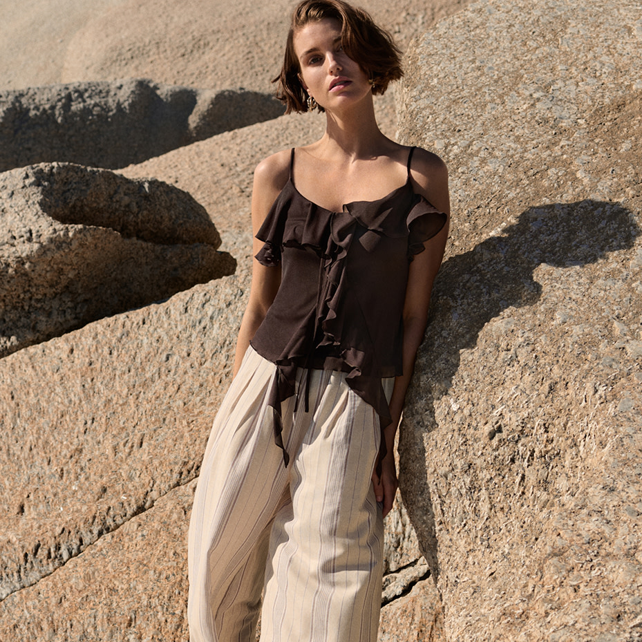 Woman in brown top against rocks