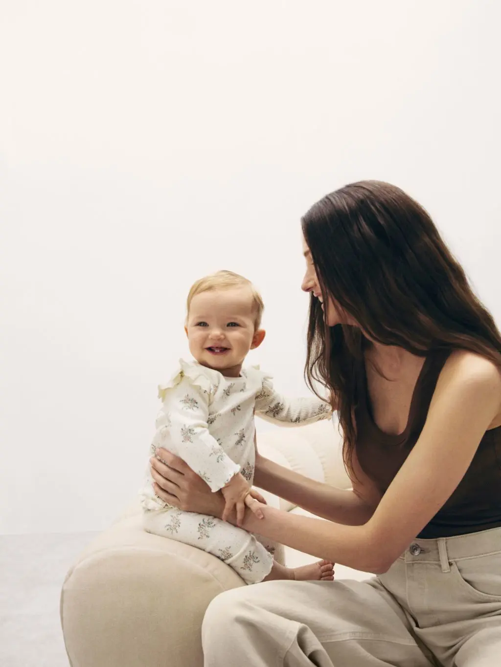 Woman with a baby sat on the sofa next to her
