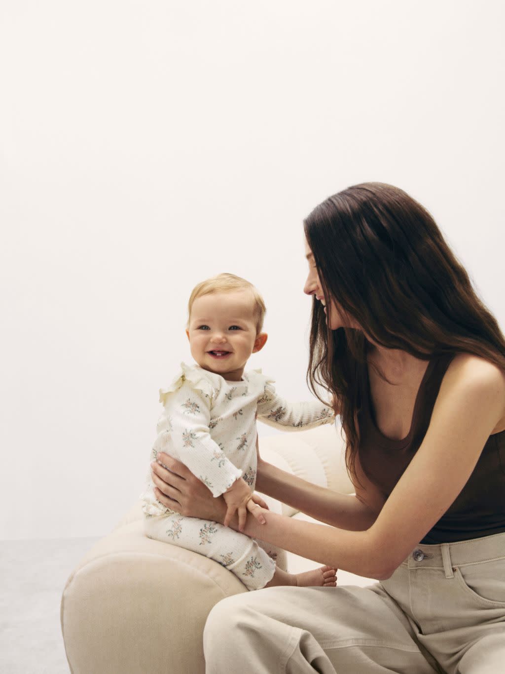 Woman with a baby sat on the sofa next to her