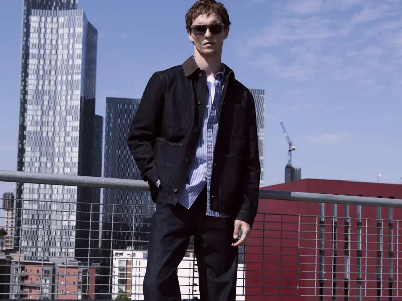 Man wearing dark indigo jeans with a blue shirt and navy jacket