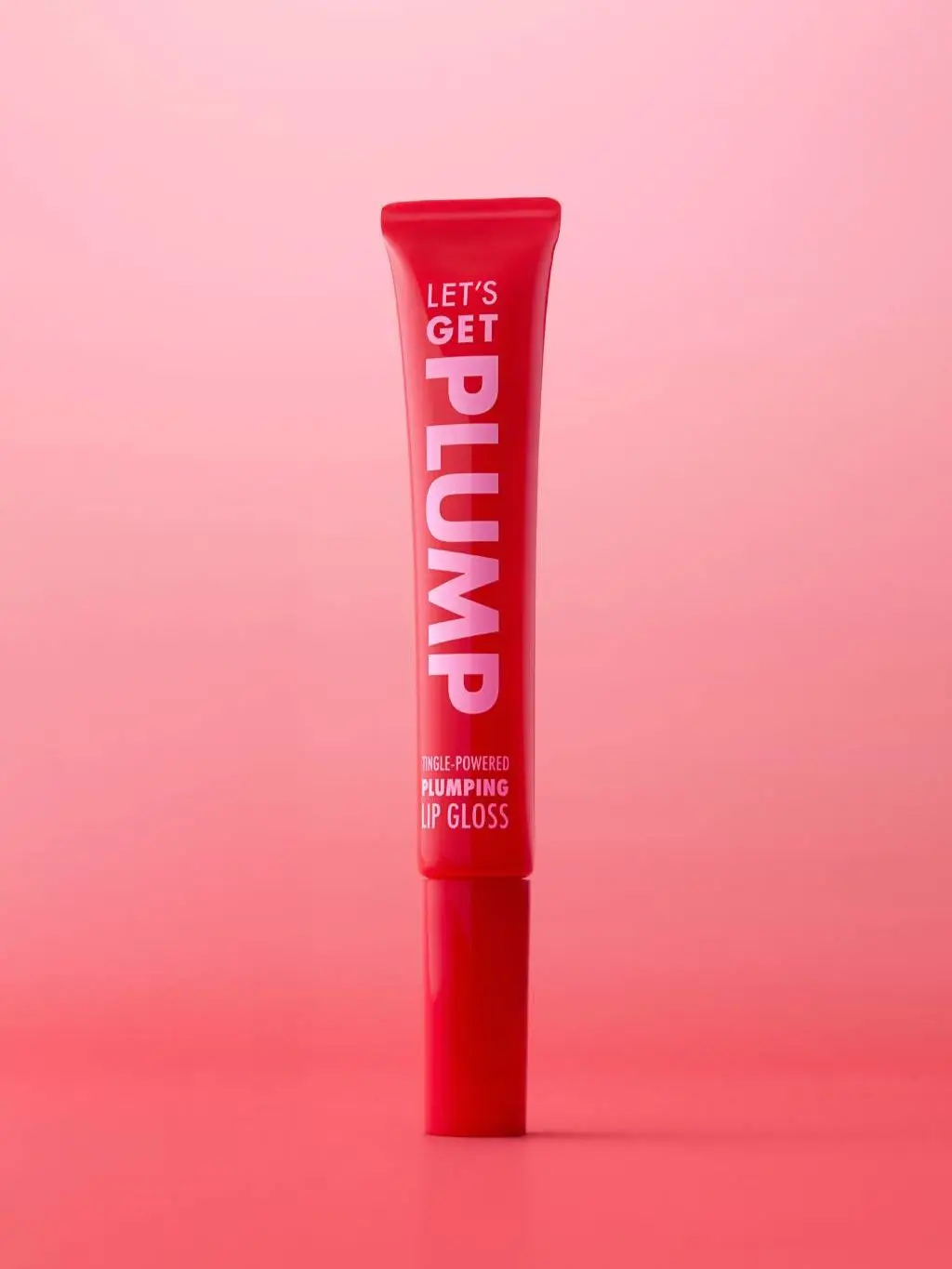 A packshot of Let's Get Plump lipgloss against a gradient pink and red background