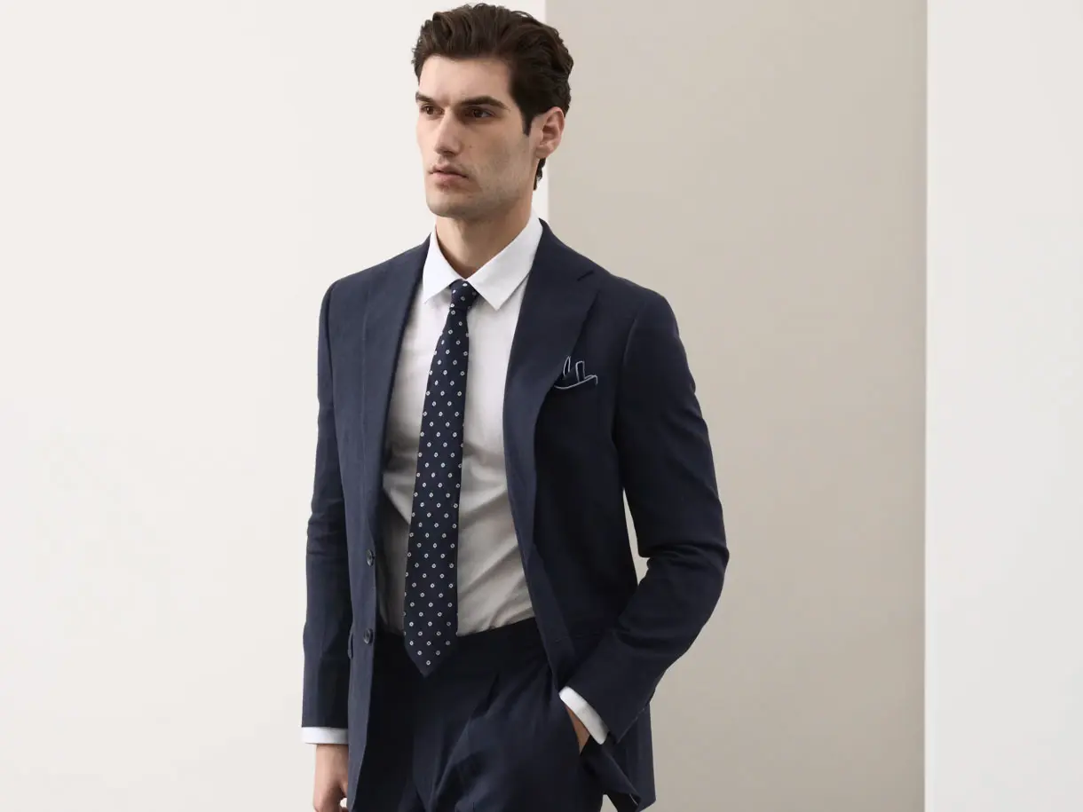 Man wearing navy suit and patterned tie