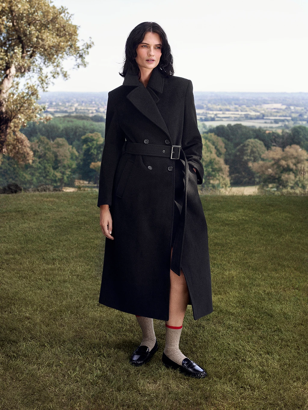 Woman wearing long wool coat by M&S x Bella Freud in the countryside