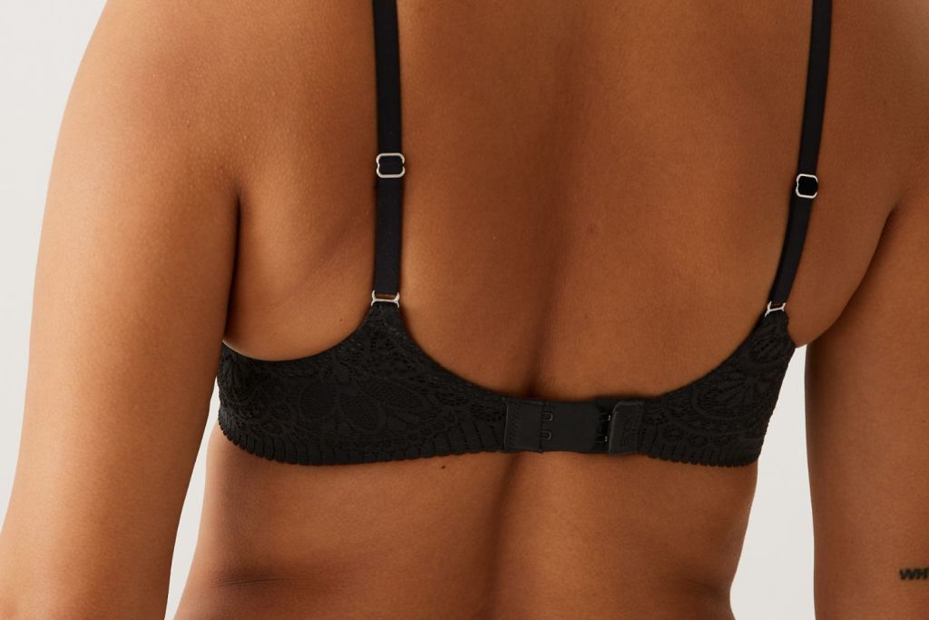 Woman wearing a bra arching up at the back.