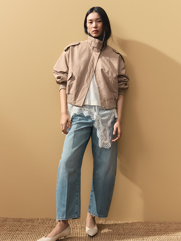 Woman in jeans and tan jacket