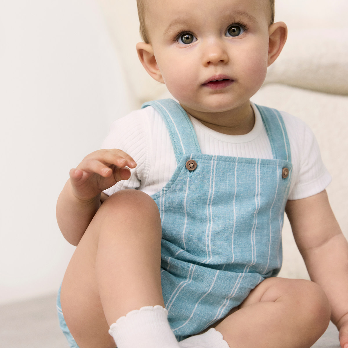 Baby wearing blue dungarees