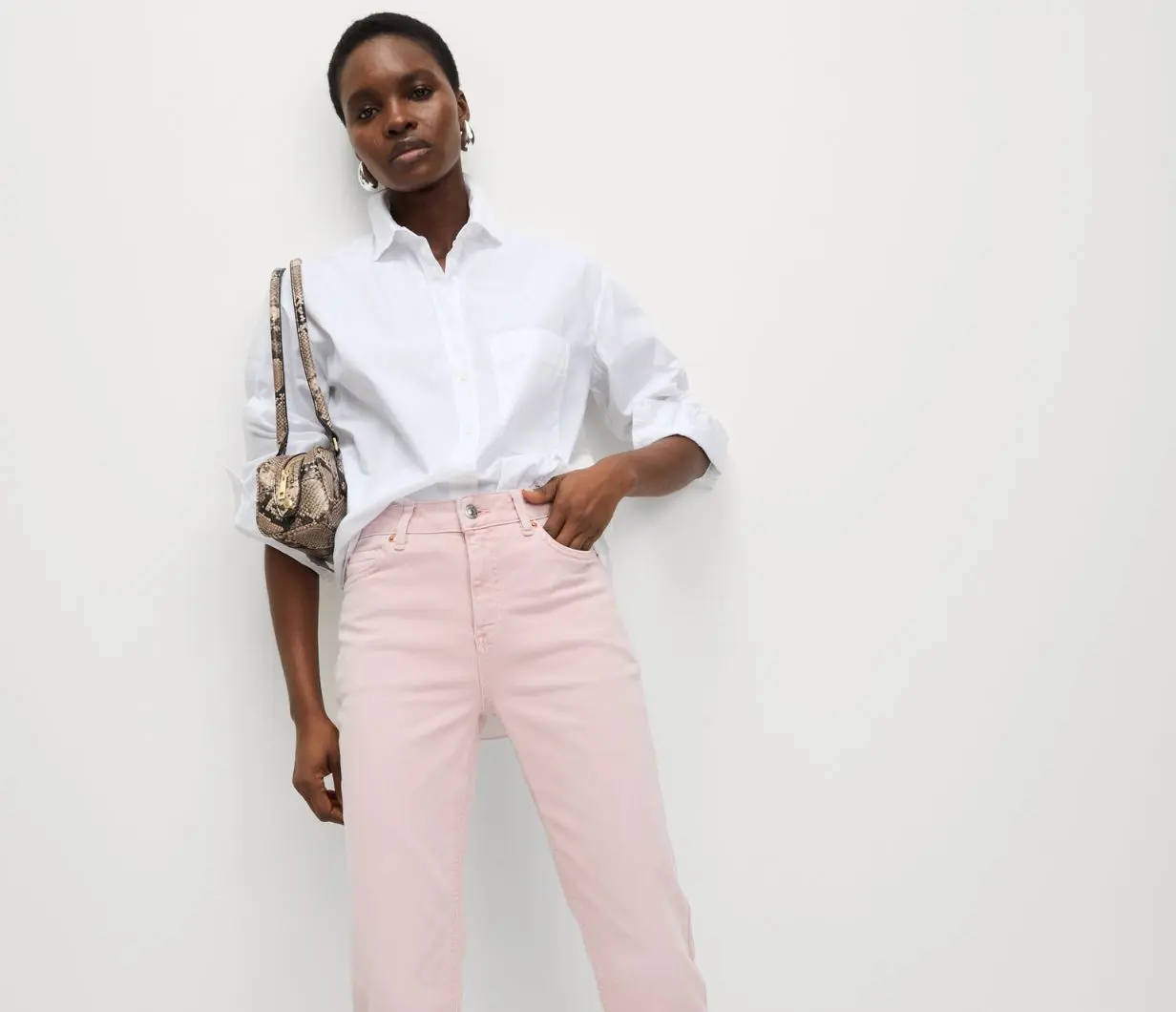 Woman wearing summery outfit of white shirt and pale pink cropped slim fit jeans