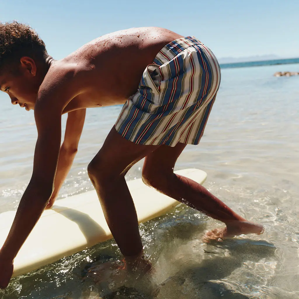 Boy wearing striped swimshorts