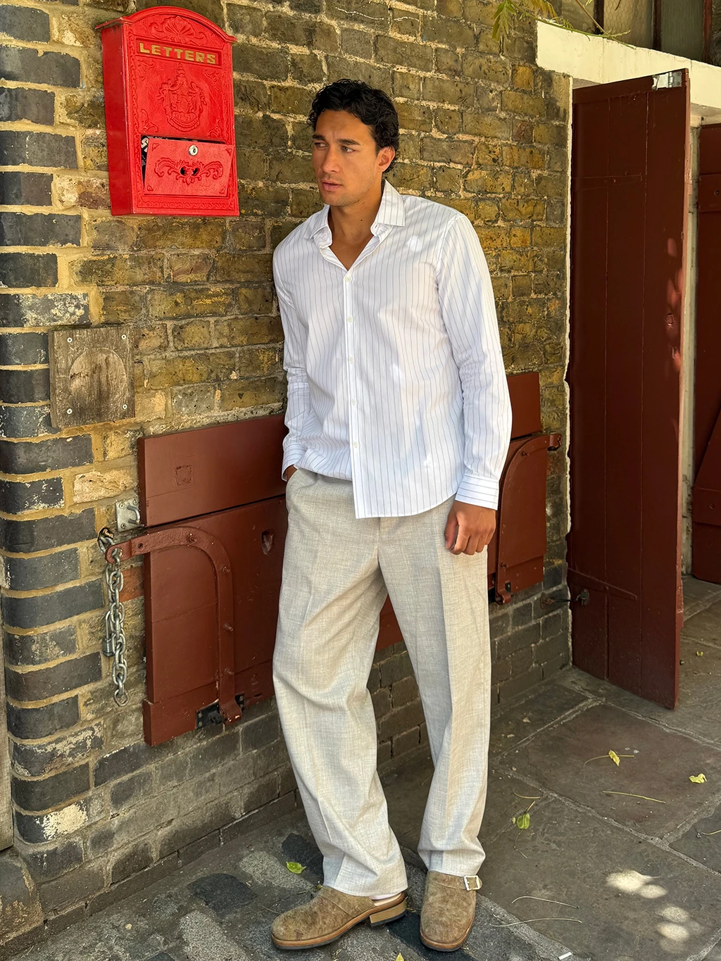 Manawa Owens in white shirt and tan trousers