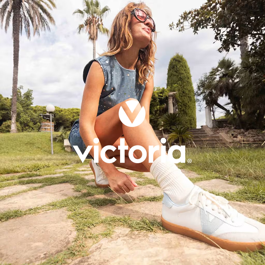 Woman wearing a denim dress and white trainers