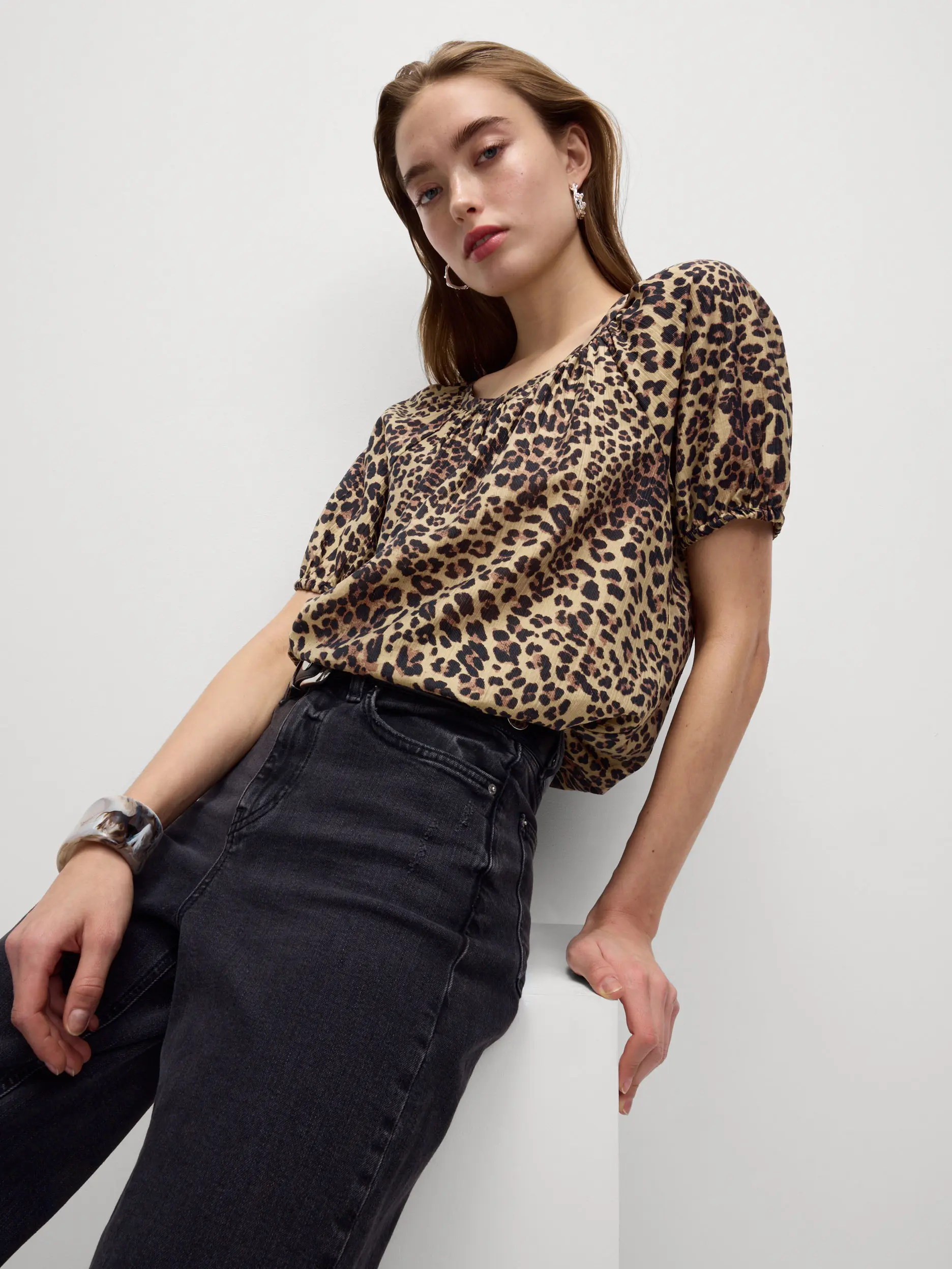 Woman wearing a leopard print top tucked into black jeans