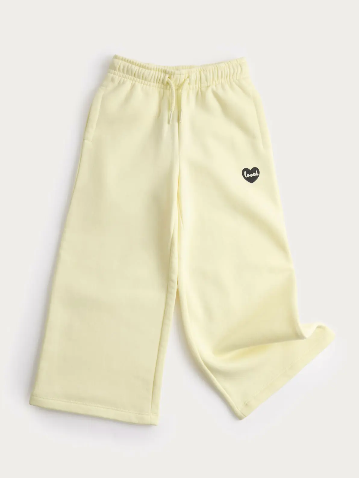 Butter yellow joggers with small black heart logo detail
