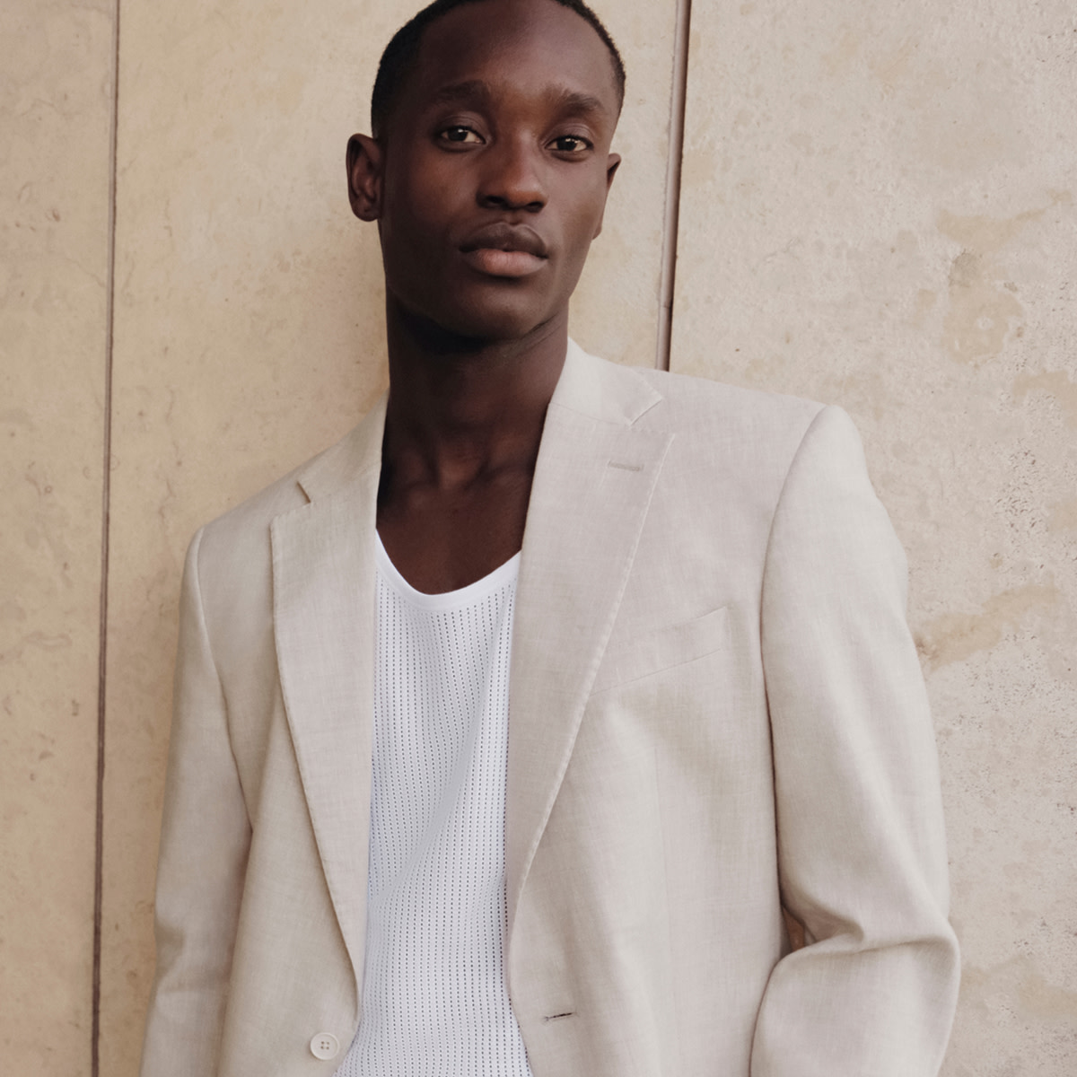 Man wearing a cream blazer and white T-shirt