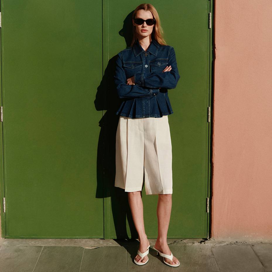 Woman in navy jacket and white trousers