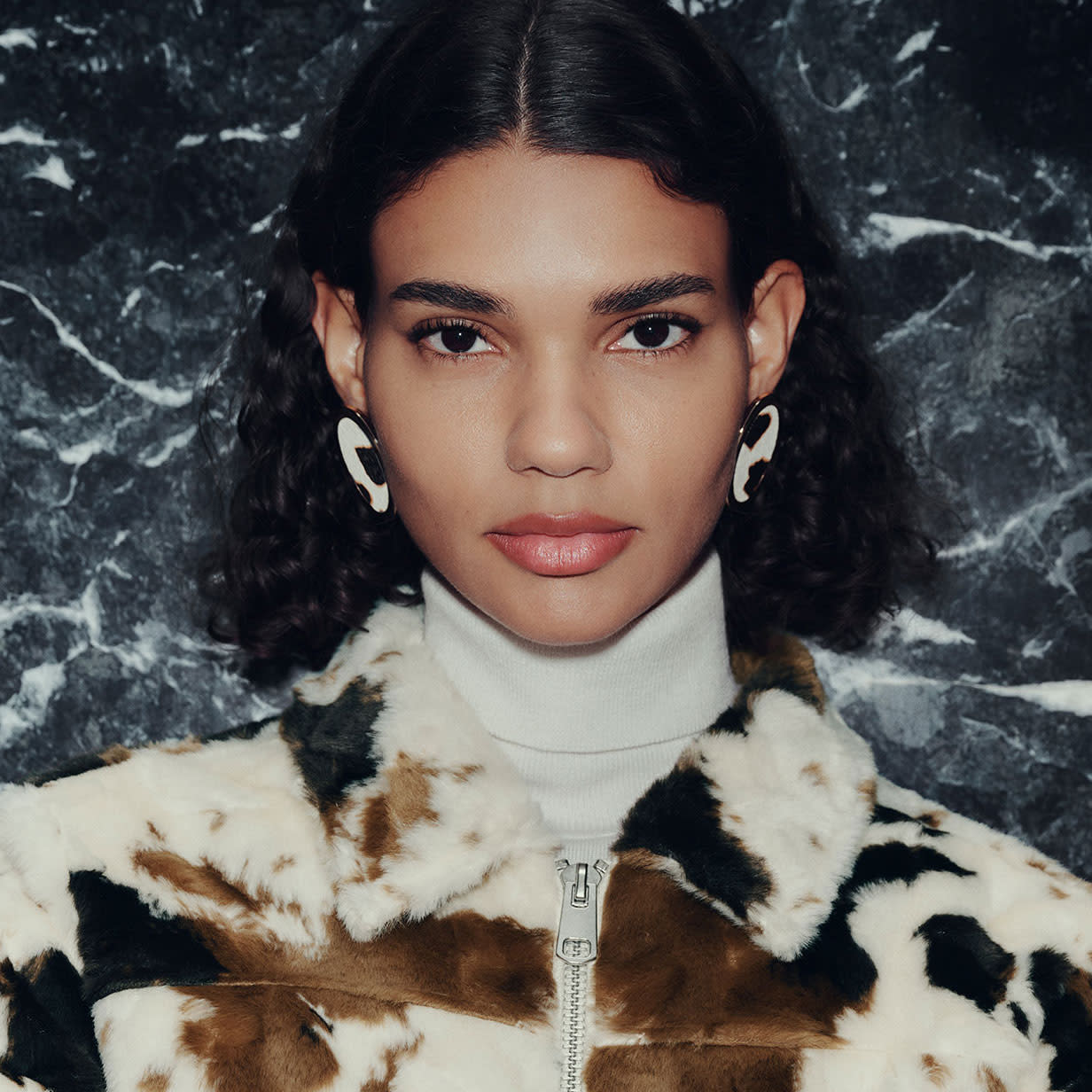Woman wearing cow-print faux fur coat