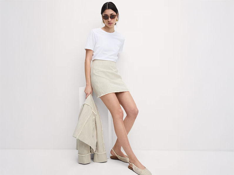 Woman wearing white T-shirt, beige mini skirt and beige pointed shoes