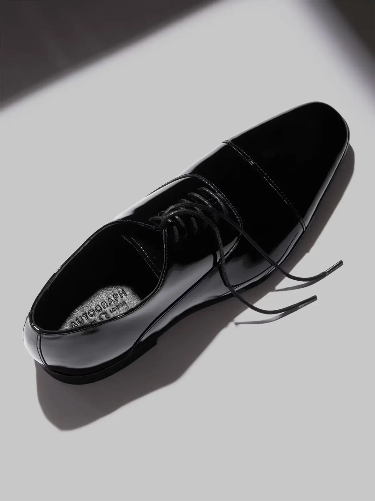 Men's patent leather formal shoe with laces undone 
