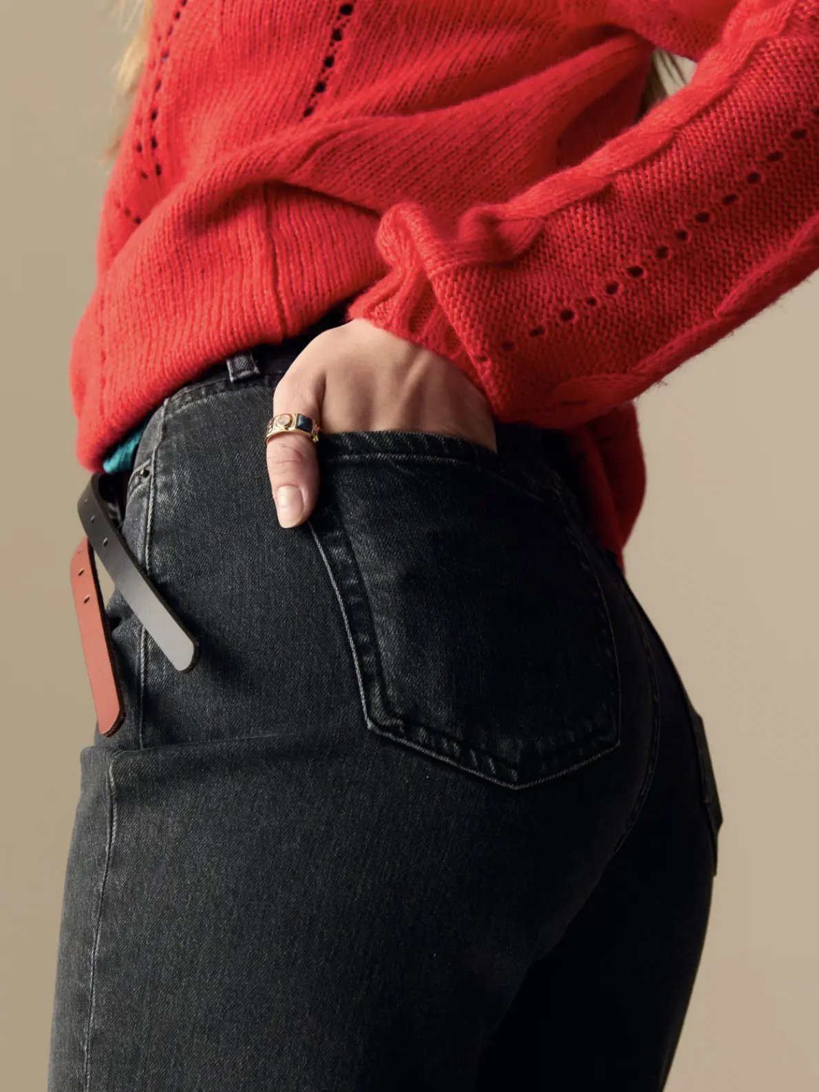 Woman wearing black jeans, red jumper and belt