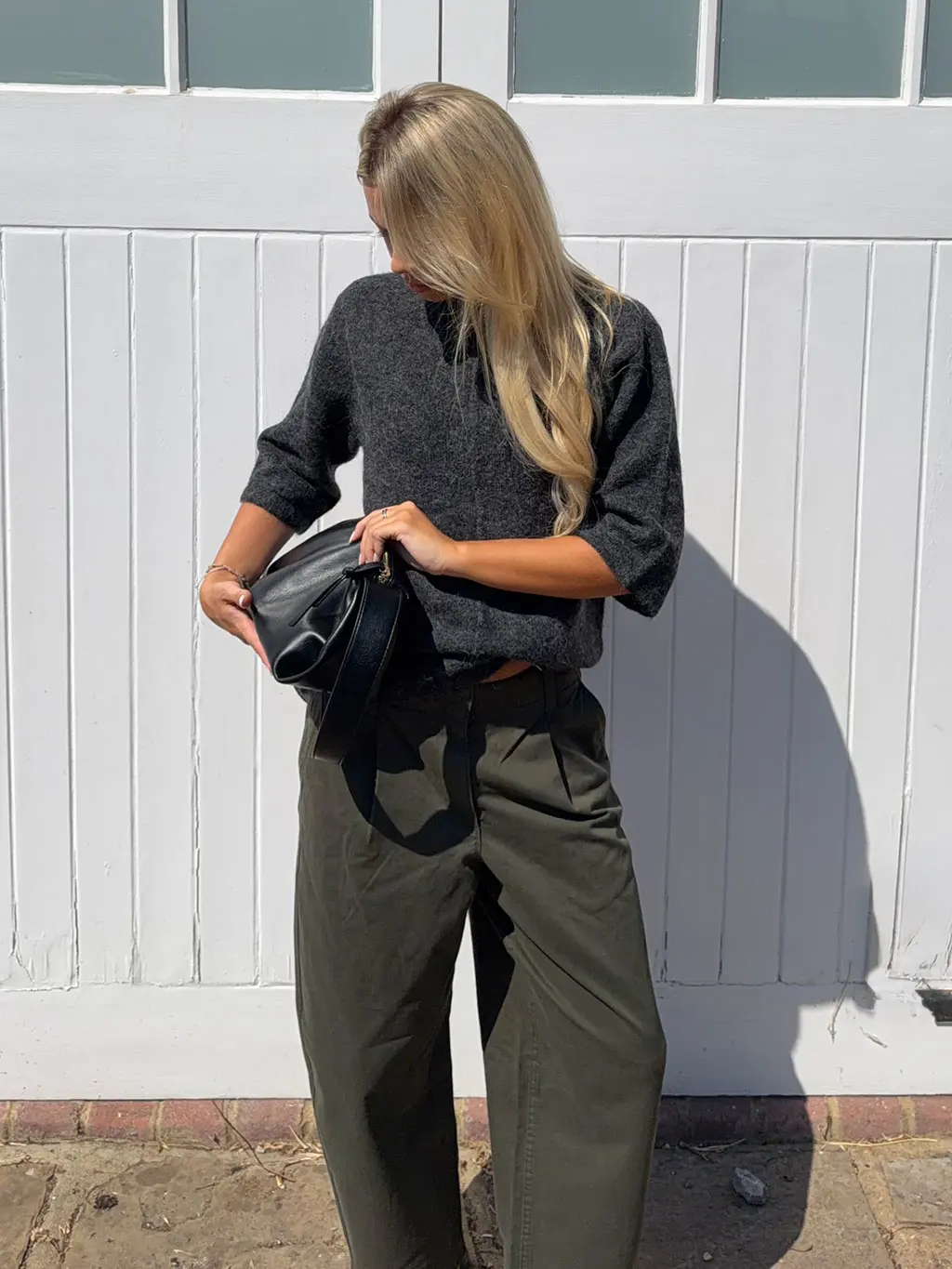 Woman in green trousers and grey sweater