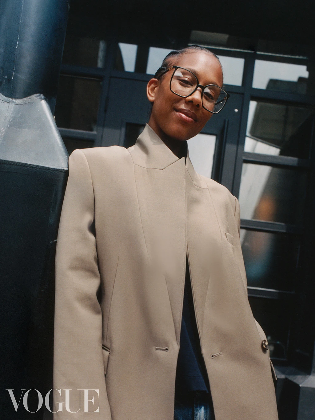 British Vogue editor Honey Sweet Elias wearing a pair of wire-framed glasses and a beige blazer by Autograph