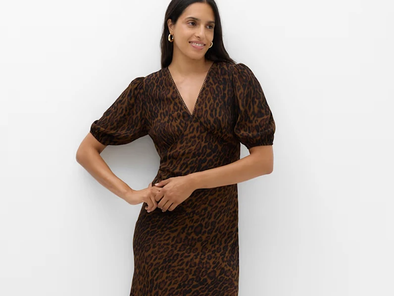 Woman in a leopard print midi dress with puff sleeves.