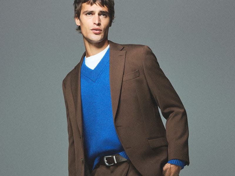 Man wearing brown blazer and blue jumper
