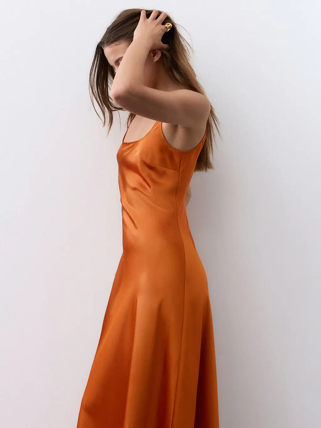 Woman wearing a rust-toned satin dress