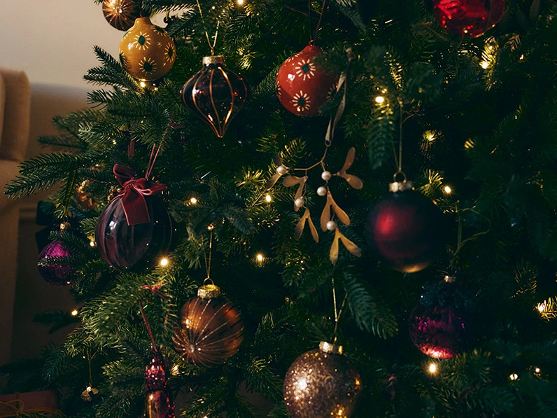 Christmas tree decorated with red and gold baubles.
