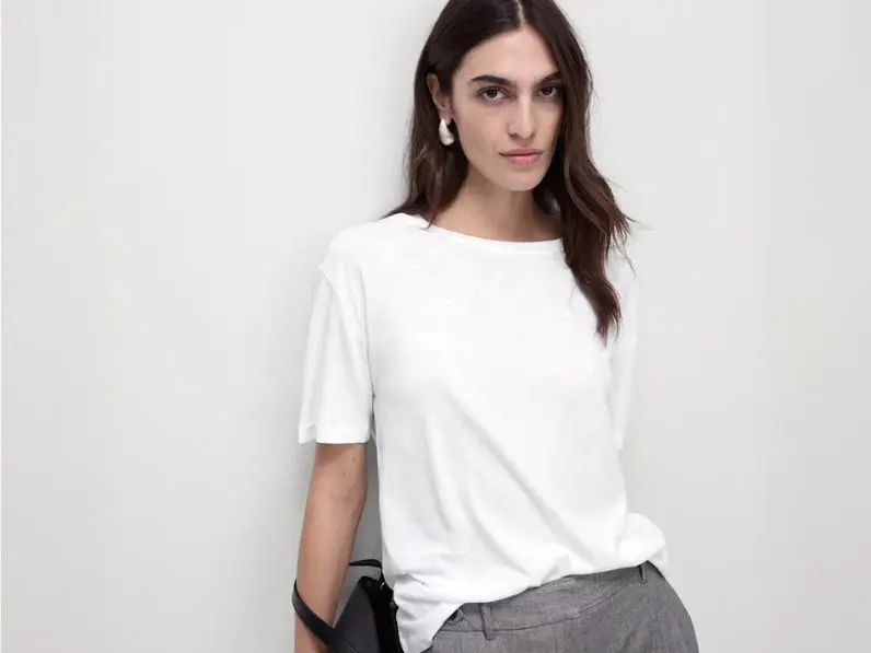 A woman wears a relaxed-fit white T-shirt with trousers