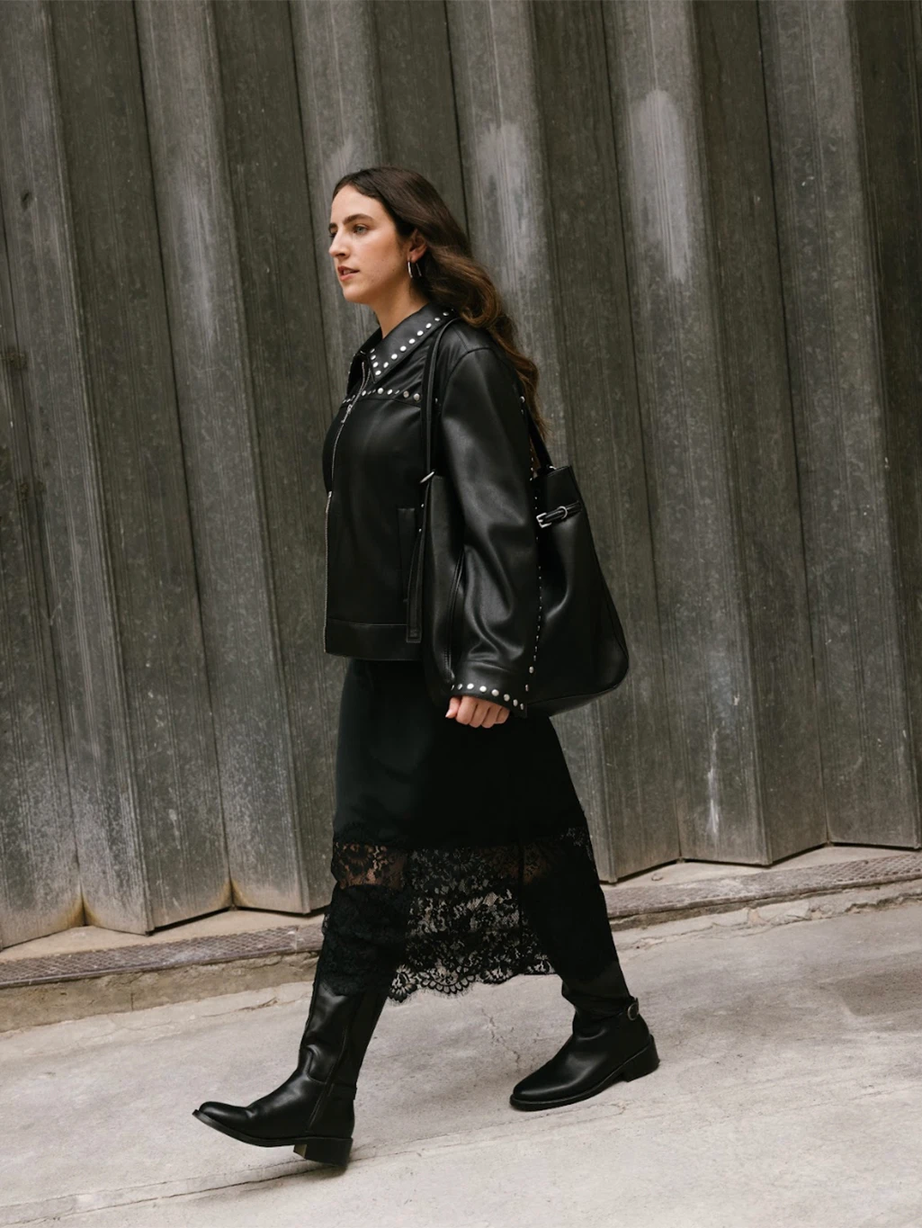 Ava Gilchrist wearing black studded jacket, black lace-trimmed dress and black knee-high boots