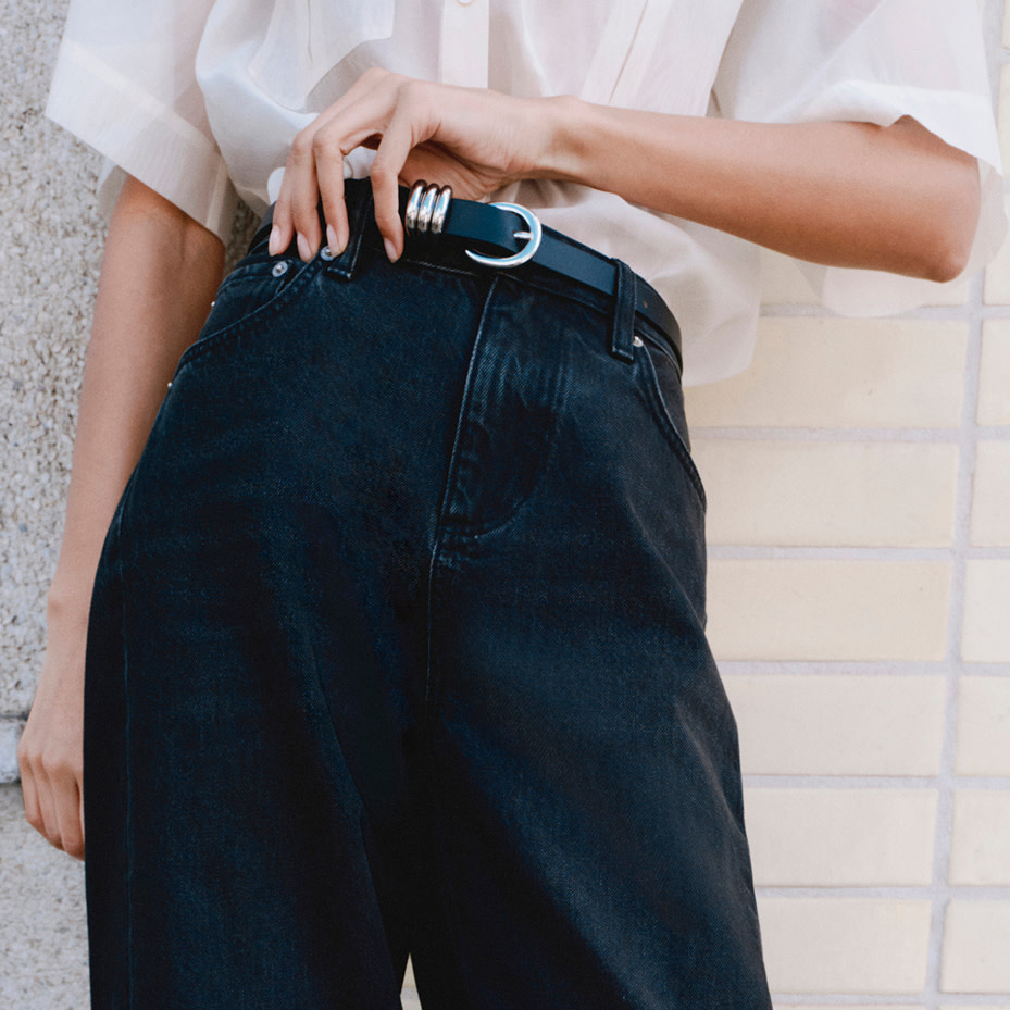 Woman wearing white shirt tucked into jeans