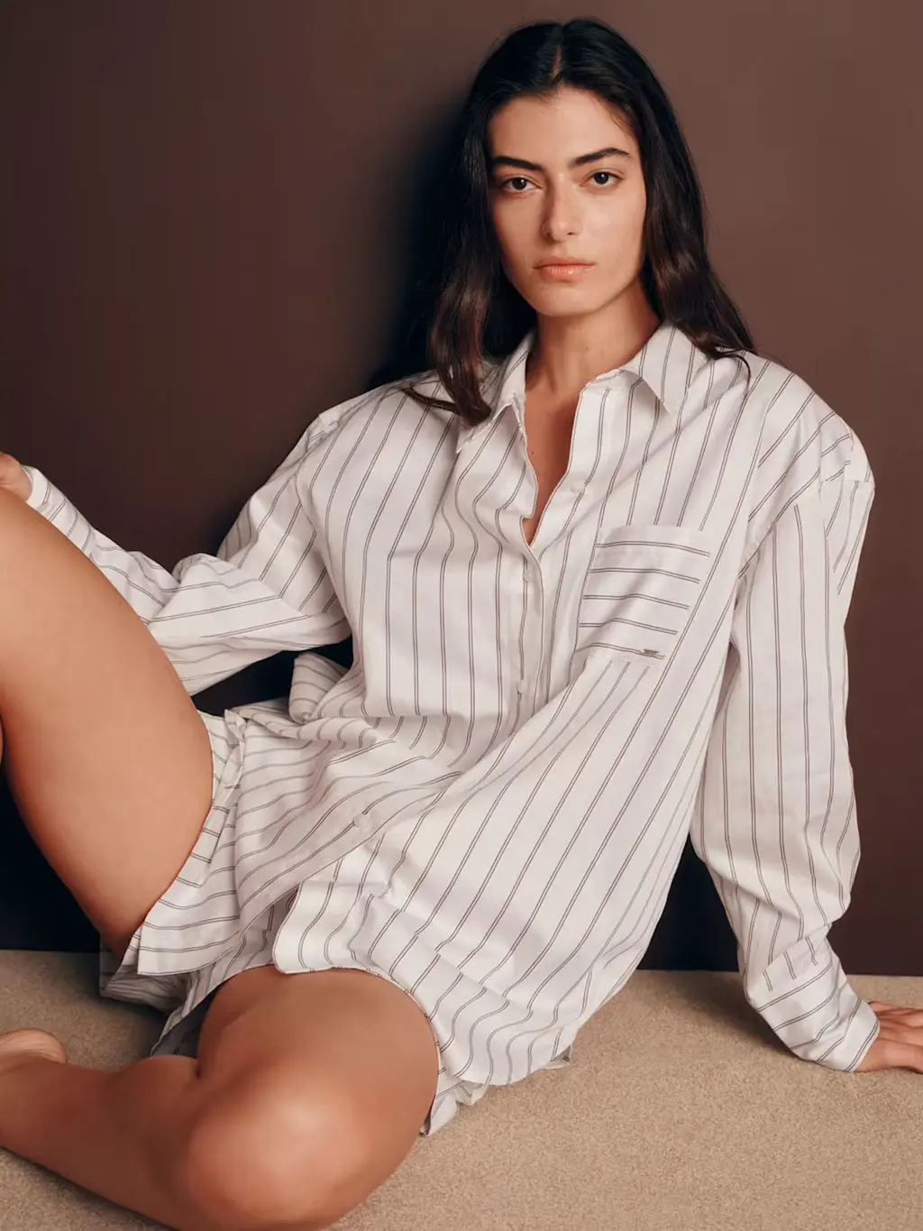 Woman wearing white and burgundy striped satin pyjamas