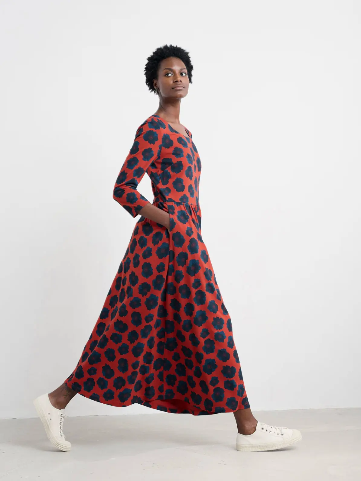 Woman wearing floral midi smock dress and white trainers 
