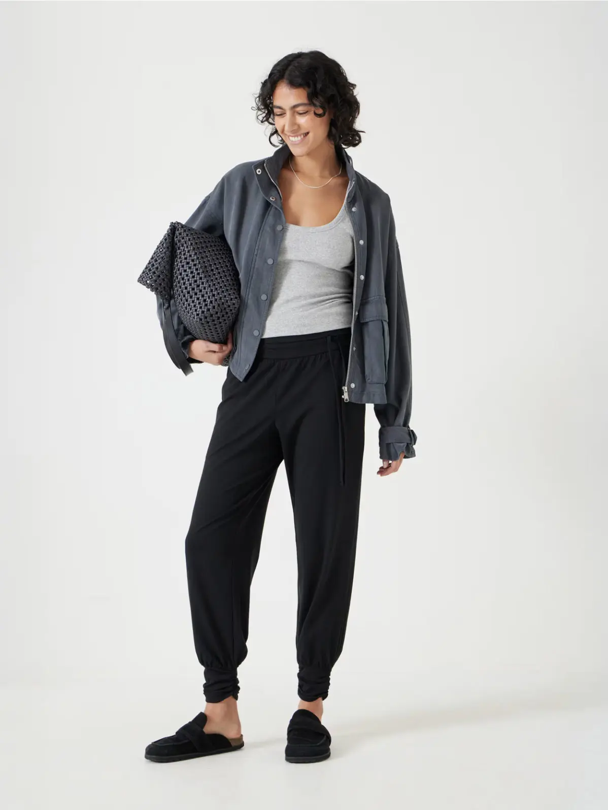 Woman wearing black baggy trousers, layers and black clogs