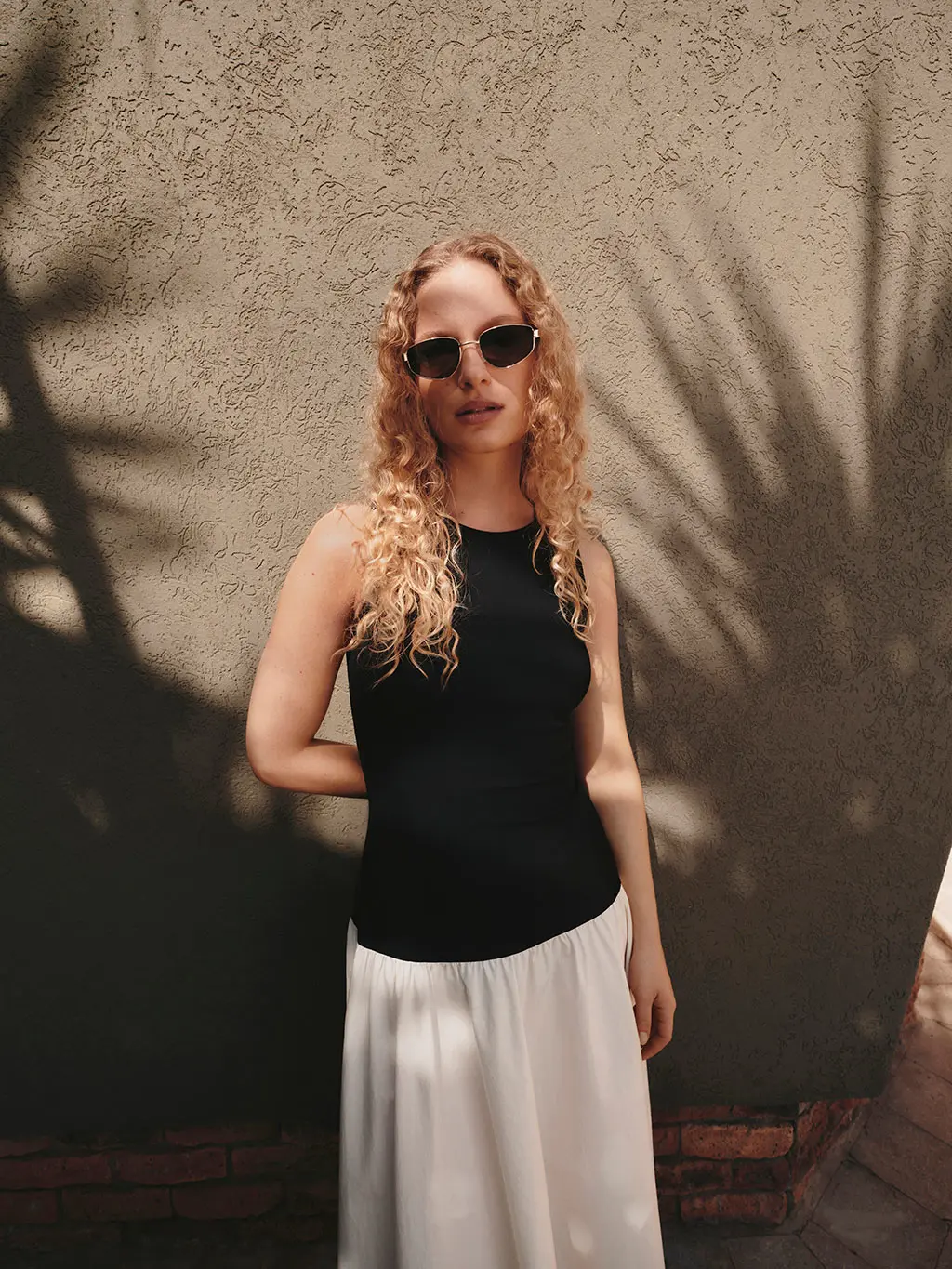 Woman wearing a black and white dress with sunglasses