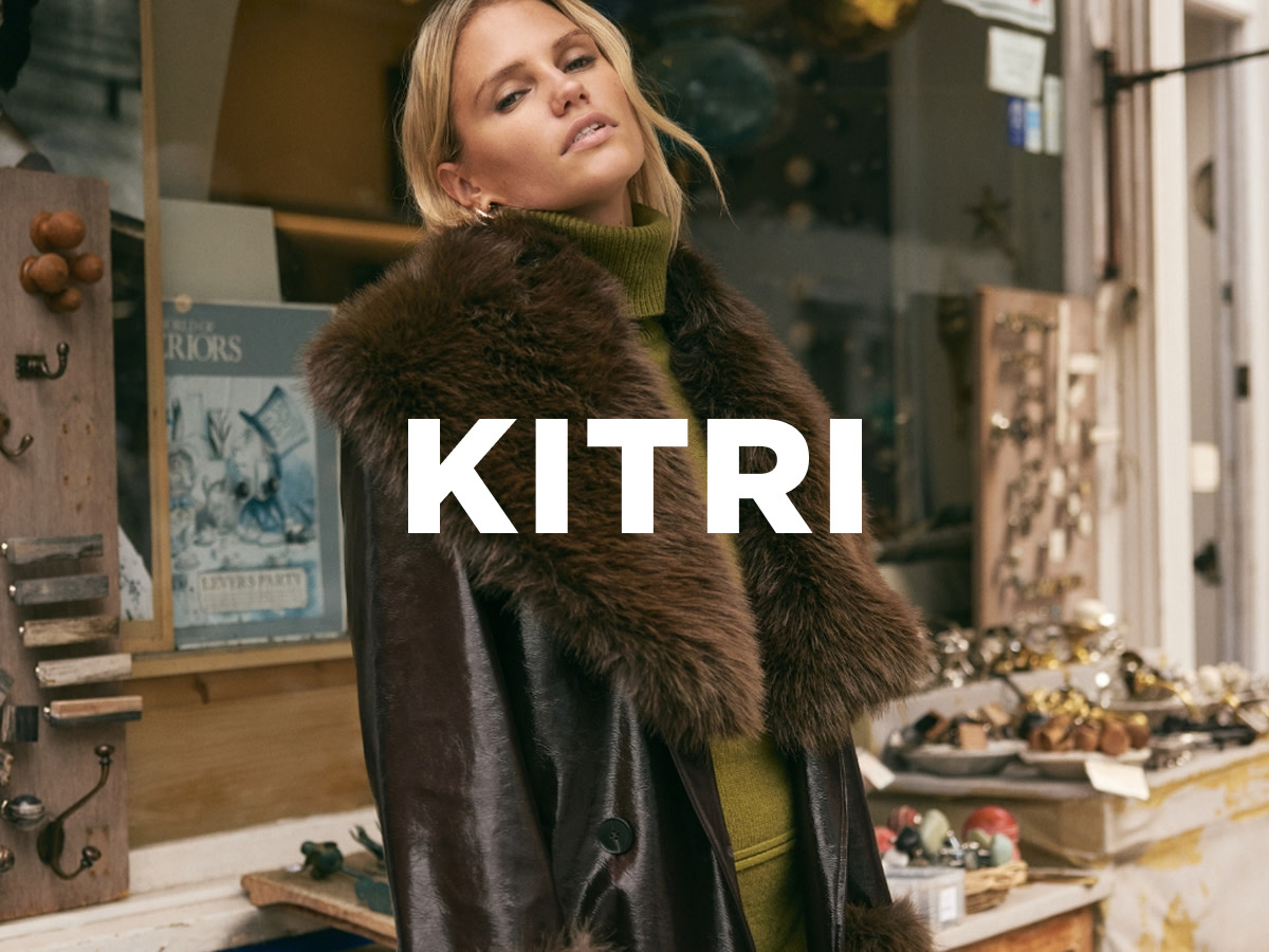 Woman wearing brown Kitri jacket with a faux fur collar