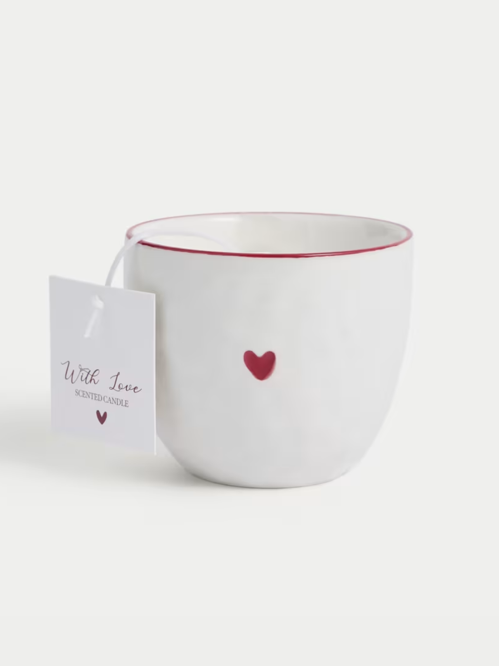 A cut out of a candle in a white container with a red heart on the side