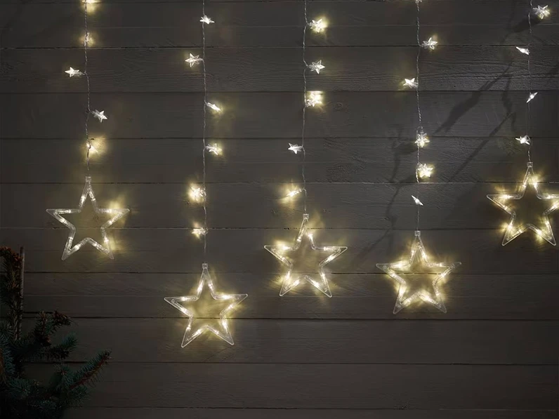 Star-shaped outdoor lights hanging on a wooden wall