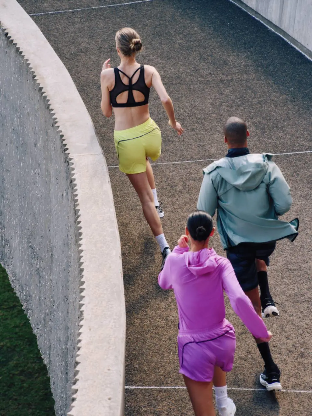 Two women and one man running in coloured sports wear