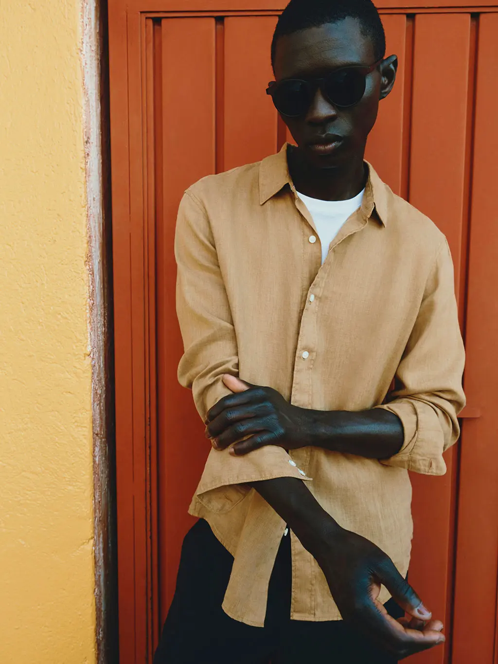 Man in sunglasses in front of orange door
