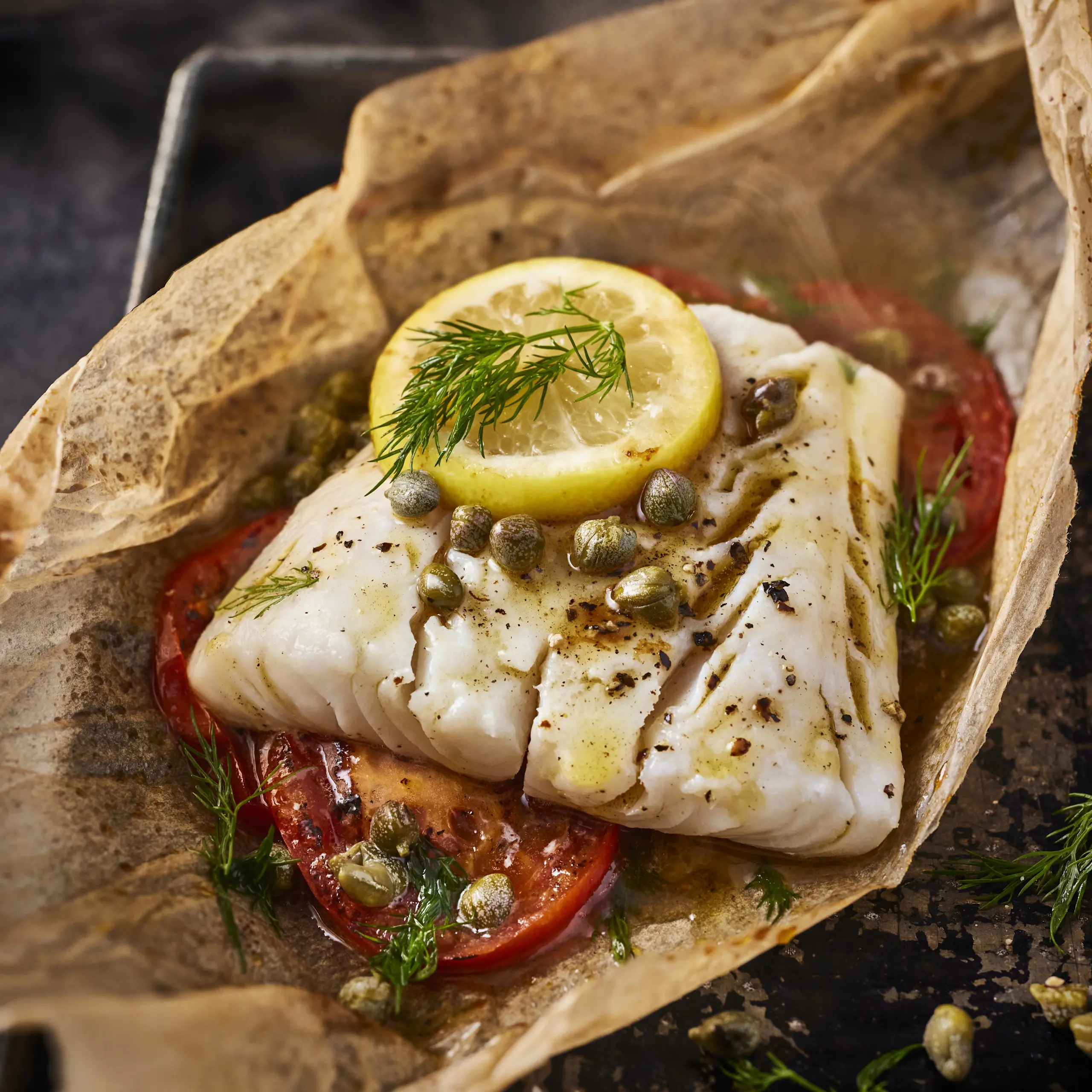 Fish with lemon on parchment paper