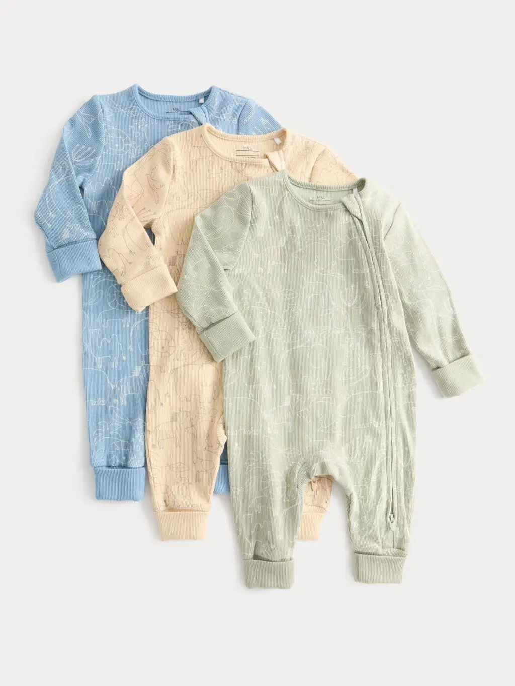 Three M&S sleepsuits laid out on top of one another