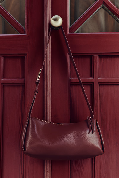 Burgundy handbag hanging on door