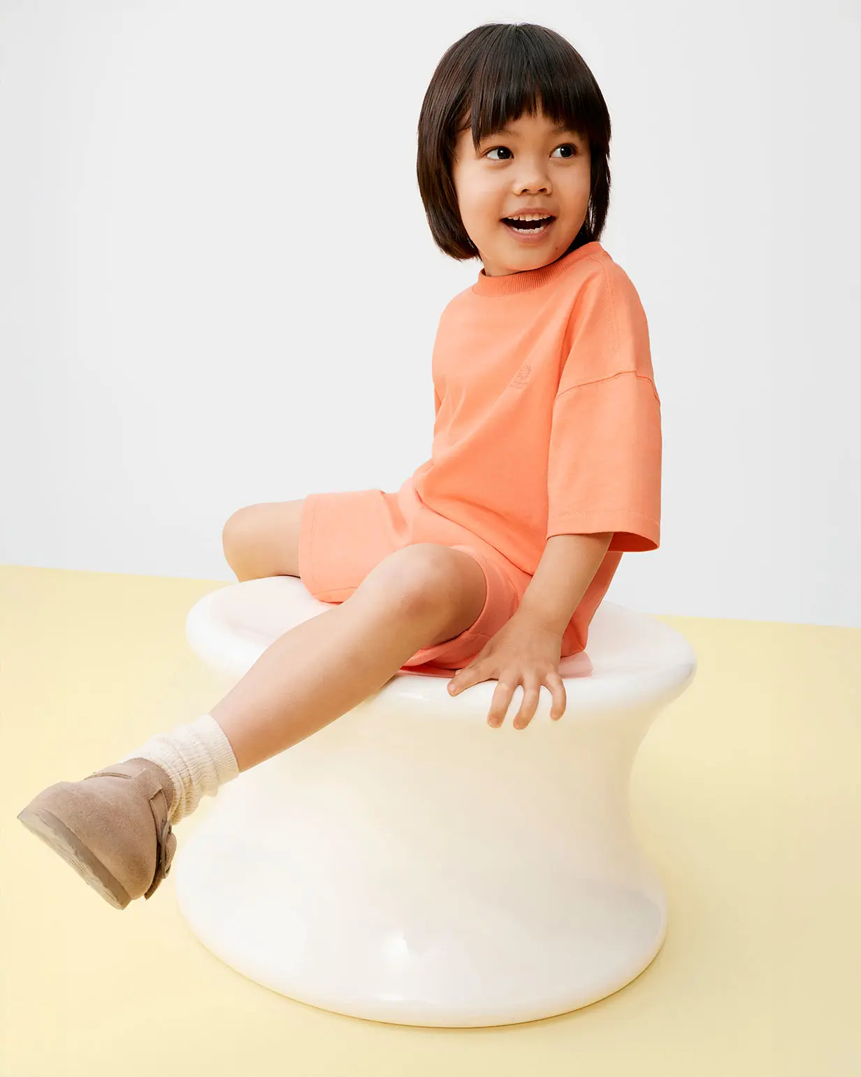 Boy wearing orange T-shirt and shorts