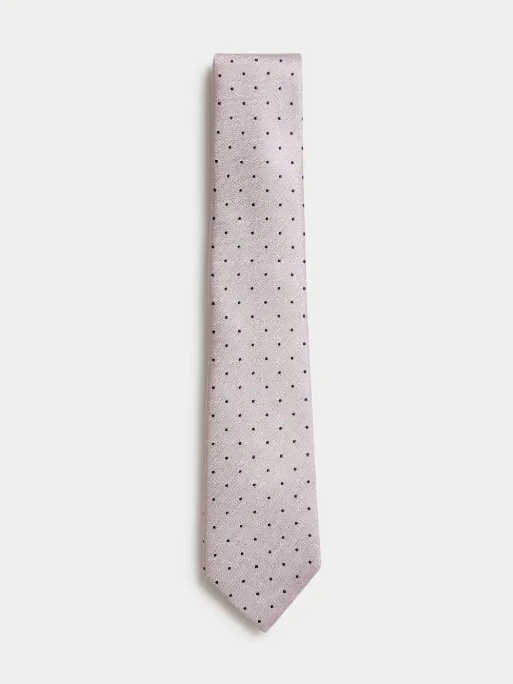 A cut out of a pink polka dot silk tie against a grey background