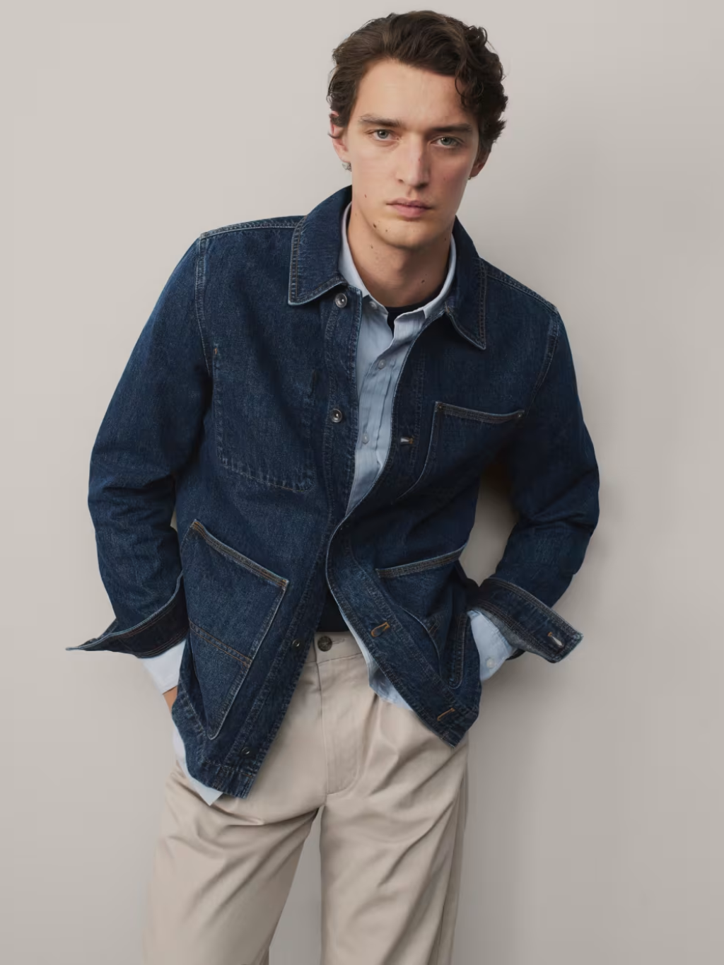 Man wearing indigo denim jacket and cream chinos