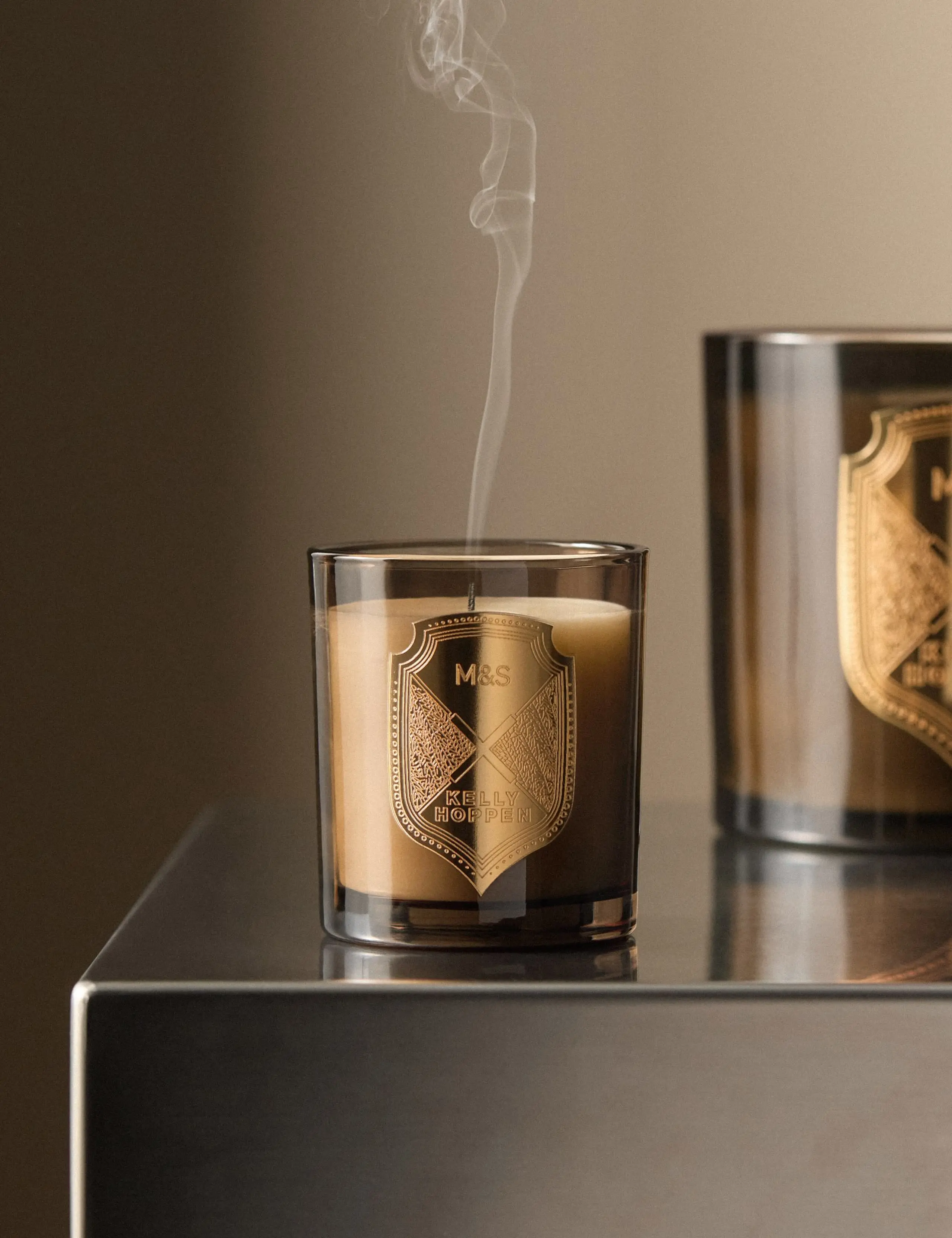 Kelly Hoppen scented candle with a gold crest on the front.