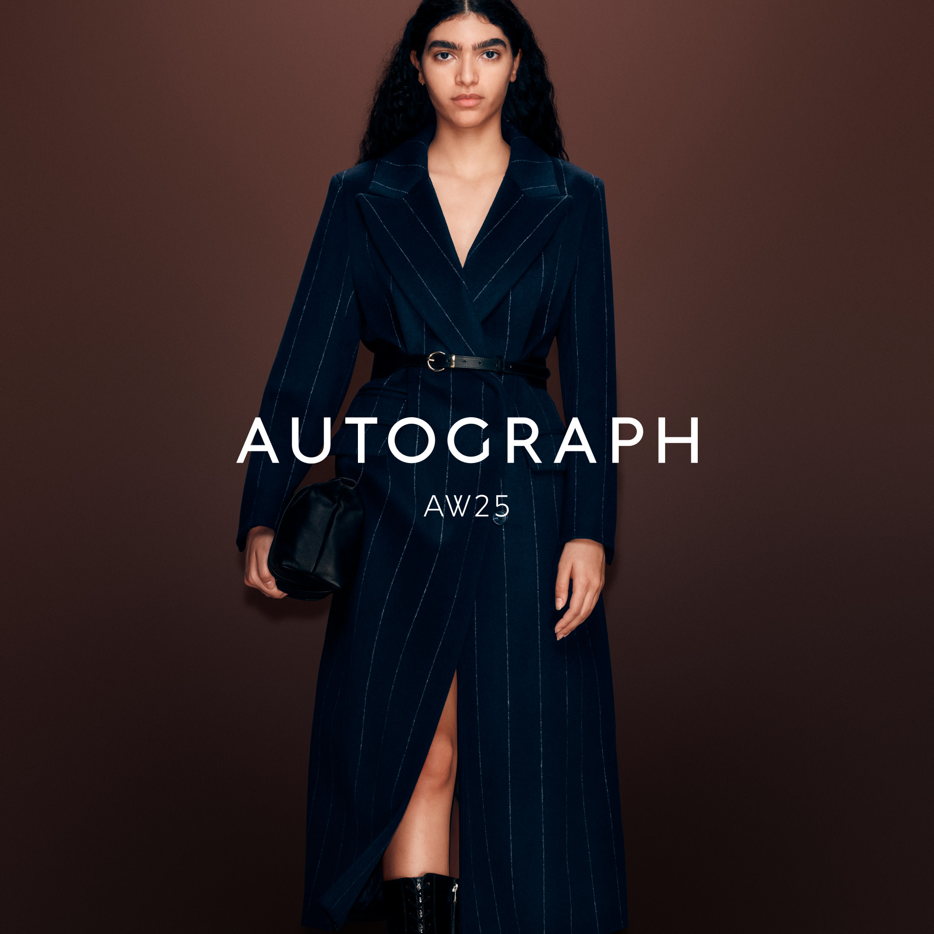 Woman wearing a navy Autograph coat with a leather waist belt
