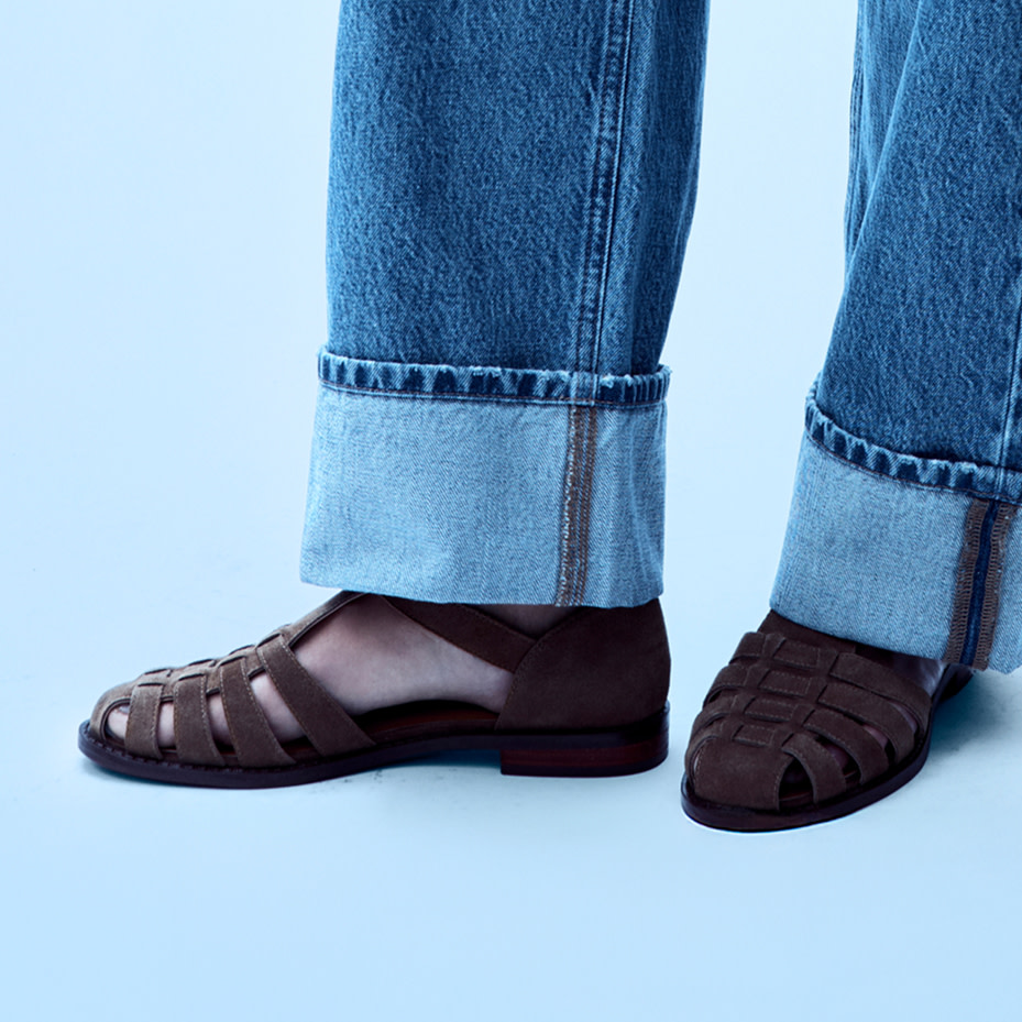 Close-up of a woman's foot wearing brown sandals