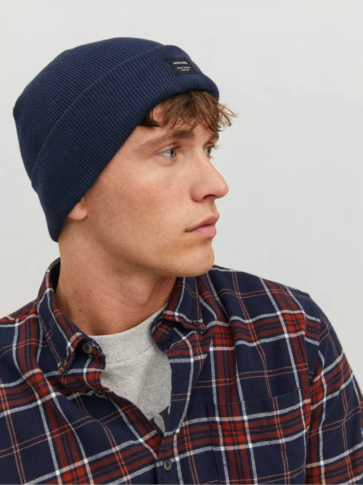 Man wearing navy beanie with checked shirt 